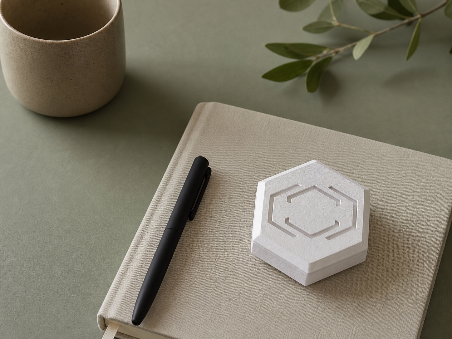 Pestr Alarm Hub beside a linen notebook on a sage desk