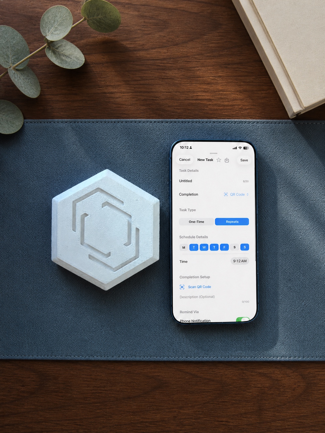 Pestr physical alarm beside an iPhone showing customizable task and reminder settings on a styled desk